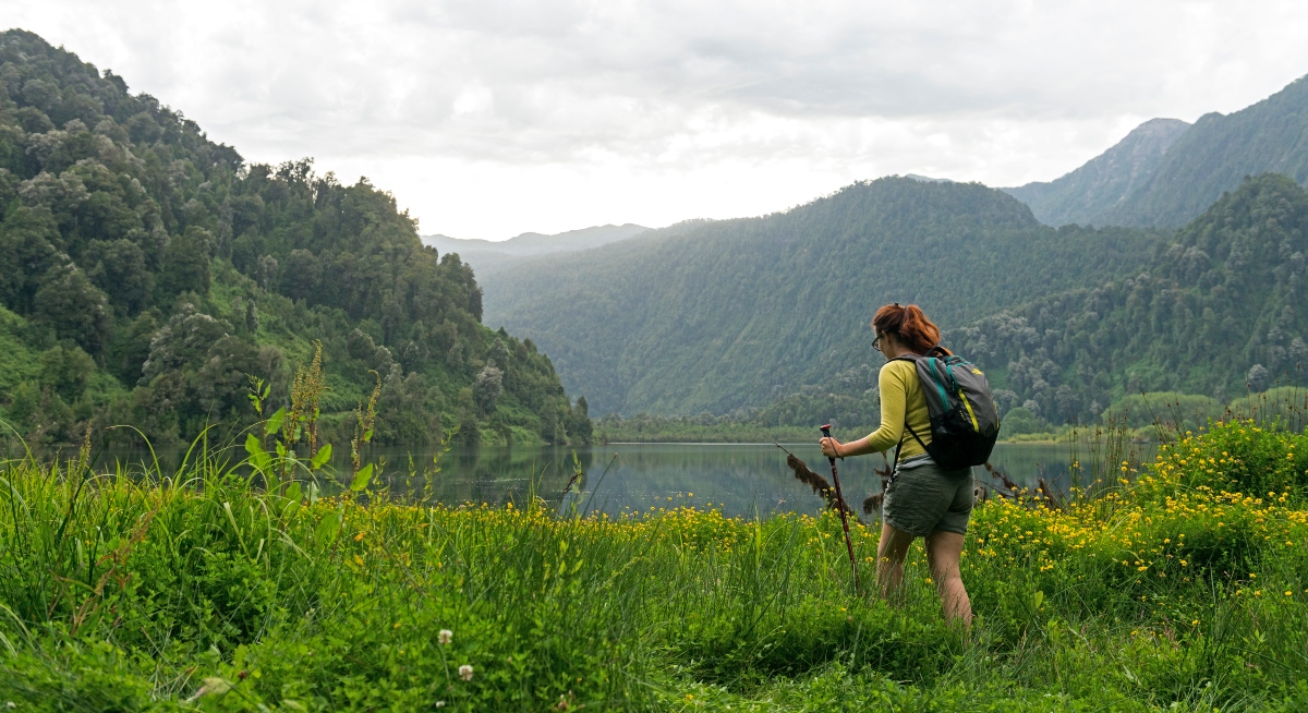 Imagen de una mujer haciendo trekking por los alrededores de la cuenca del lago Ranco