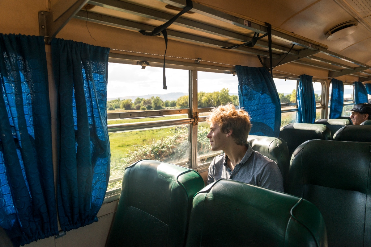 Imagen de una persona disfrutando del paisaje en el tren Ramal Talca Constitución