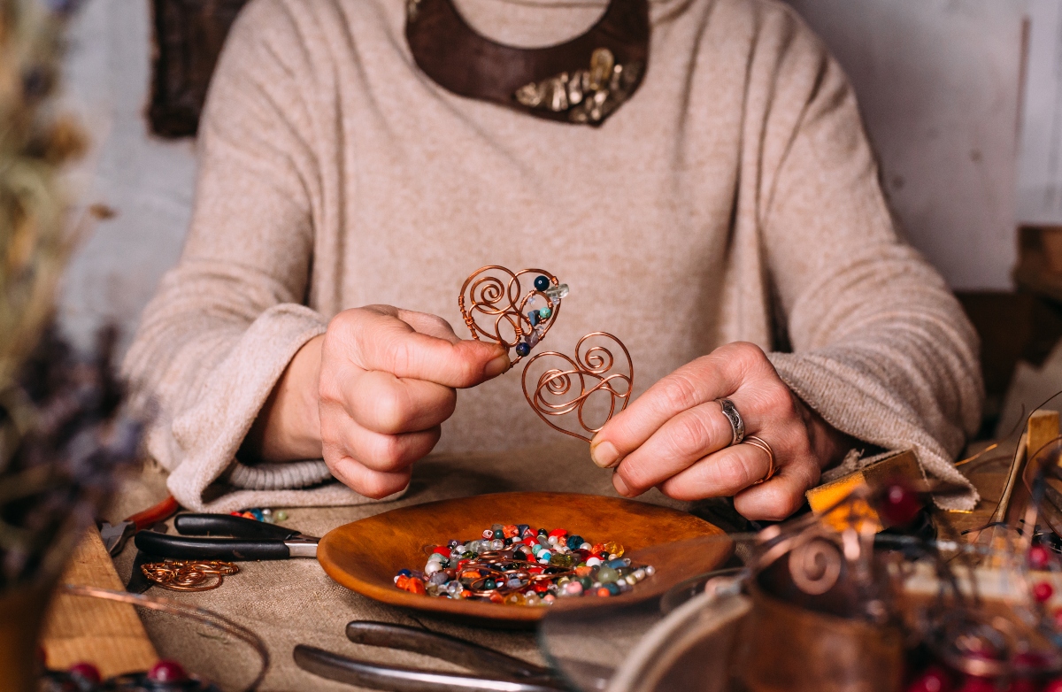 Imagen de una mujer mostrando su artesanía en cobre
