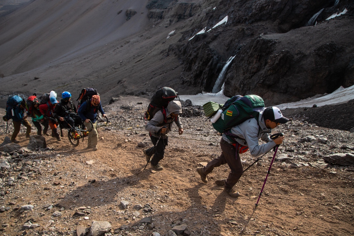 Imagen de un grupo de personas escalando una montaña en Chile con un chico en silla de ruedas