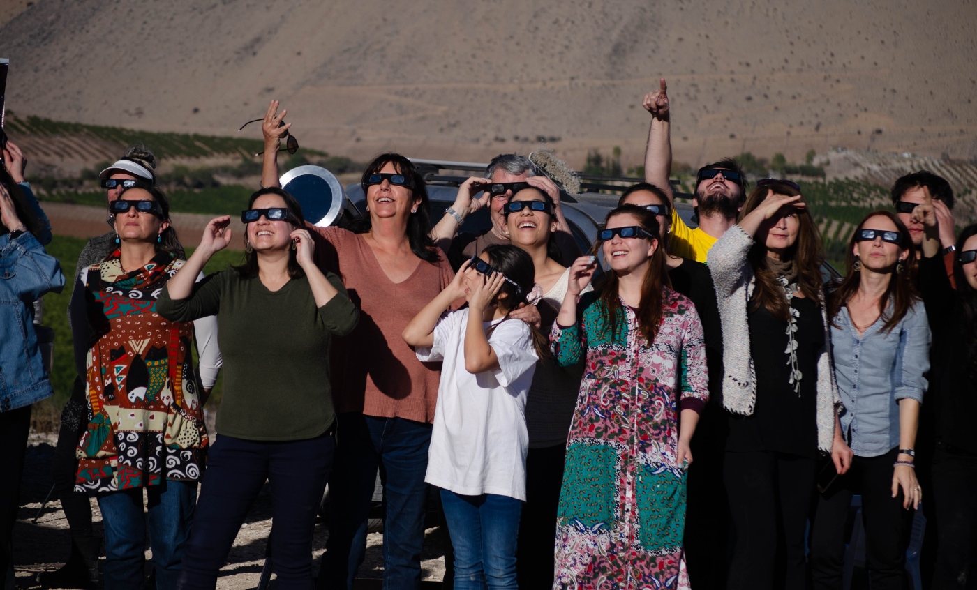 Imagen de un grupo de personas observando el eclipse solar en Chile con lentes de protección